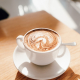 white ceramic cup with saucer on brown wooden table